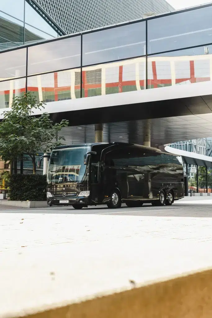 A big black luxury coach in front of the Frankfurt fair waiting for vip passangers.
